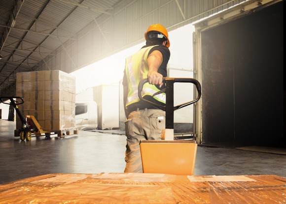 Worker pulling a box in a factory.