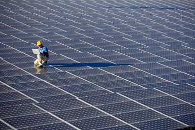 An engineer with a laptop working at a photovoltaic farm.