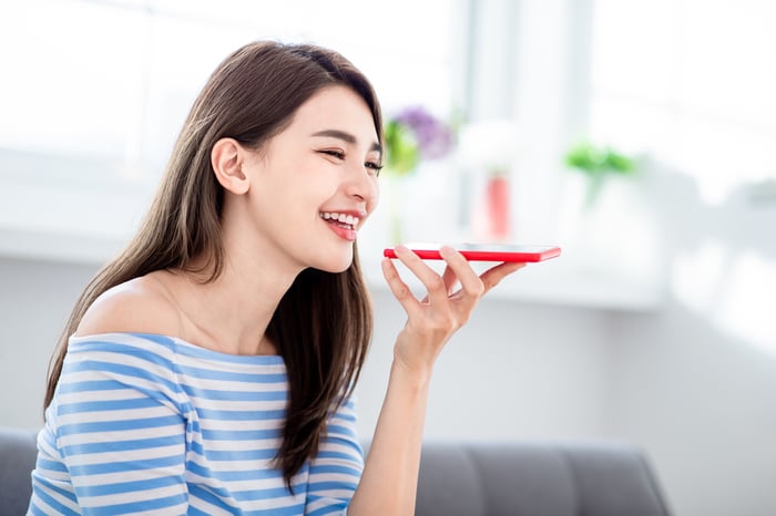 A woman conducts a voice search on her smartphone.