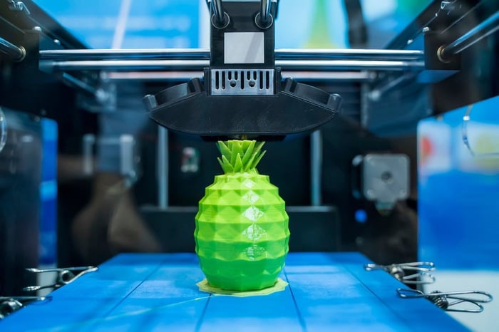 3D printer producing a green plastic pineapple.