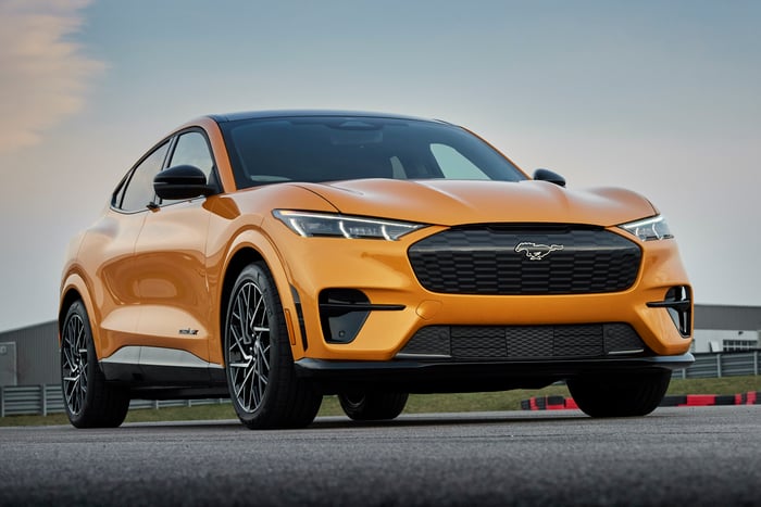An orange 2021 Ford Mustang Mach-E GT, a high-performance electric crossover SUV.