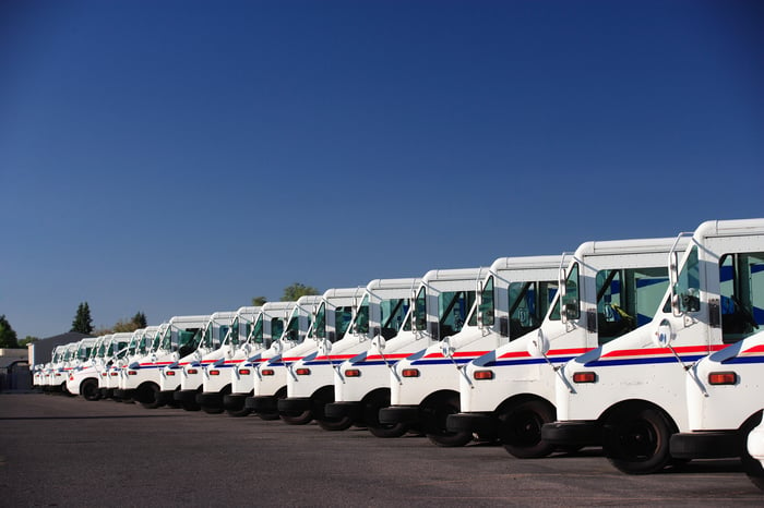 A row of postal delivery vehicles.