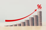 Rising stack of coins with an arrow pointing upwards -- GettyImages-1083510246
