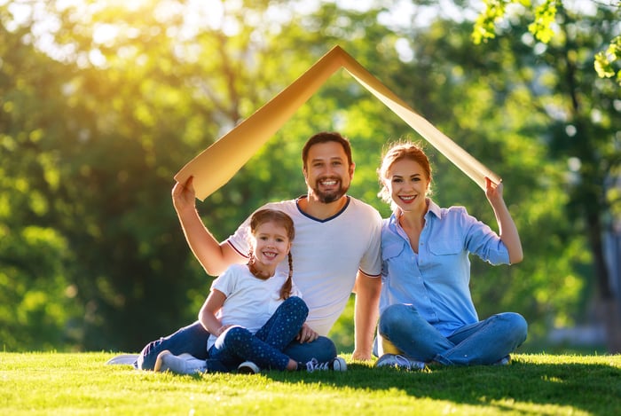 A family holding a box over their head to look like a house.