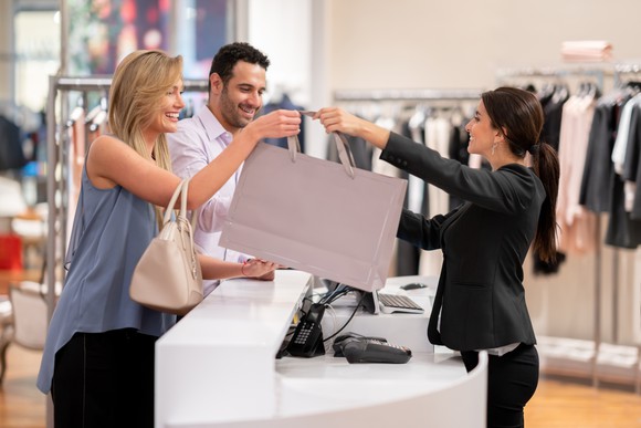 Shoppers with a sales associate at a department store.