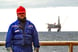 20_11_24 A man in a blue work suit with an oil rig in the background _GettyImages-869933674