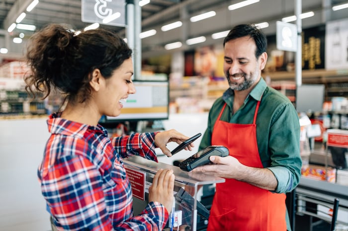A person paying with a mobile wallet in a store.