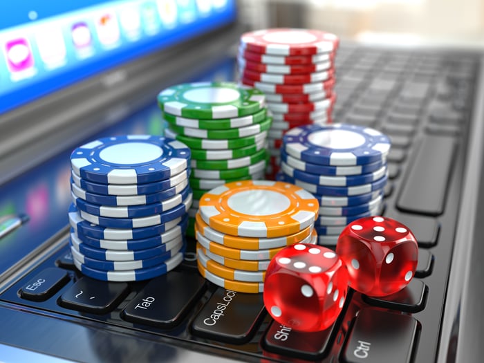 Casino chips and dice on a computer keyboard