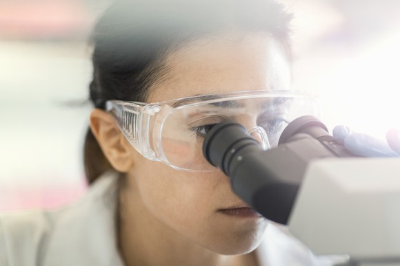 Scientist looking into a microscope.