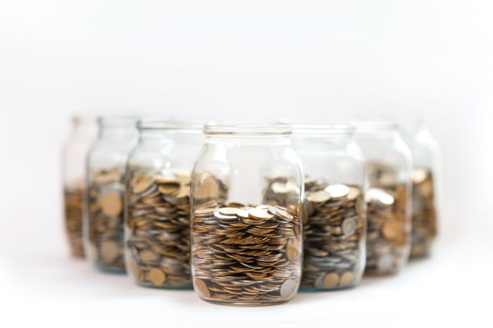 Jars full of coins lined up in a triangle shape pattern.
