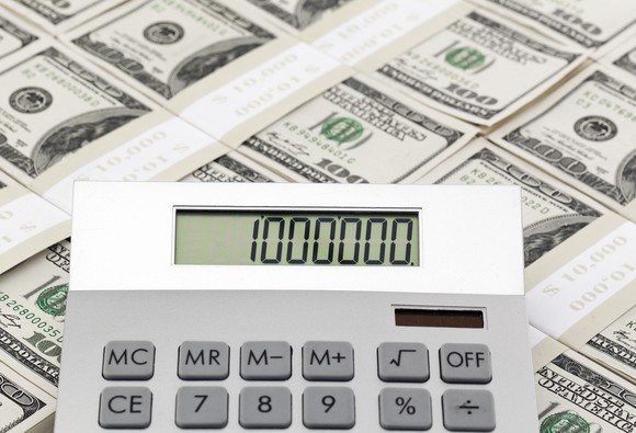 Stacks of cash with a calculator reading 1 million, to represent retiring a millionaire.