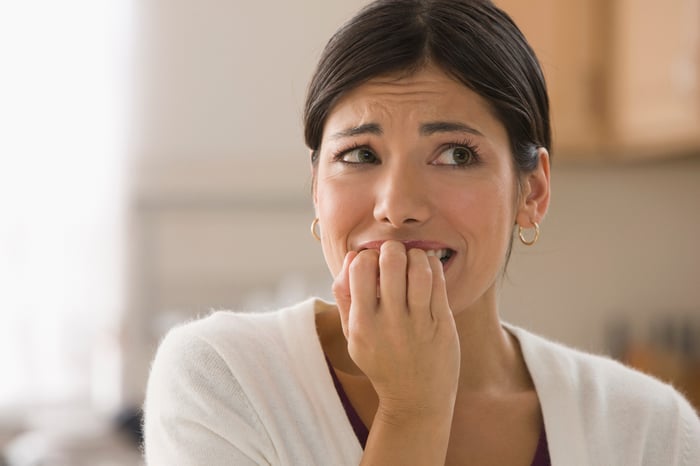 Closeup of woman with nervous expression biting nails