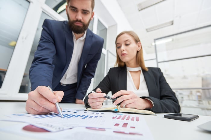 Man and woman working to prepare financial earnings restatements