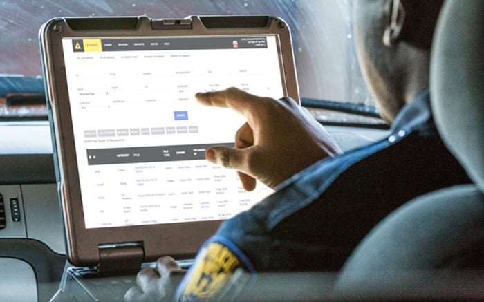 Police officer entering data into in-car computer system