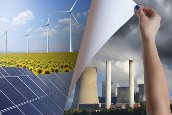A hand replacing a poster of power station chimneys by one with wind mills and solar panels.