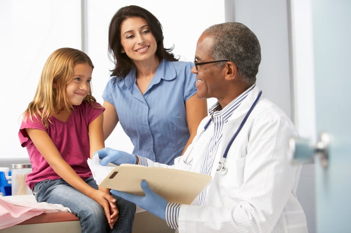 Mother and daughter speaking with a doctor.