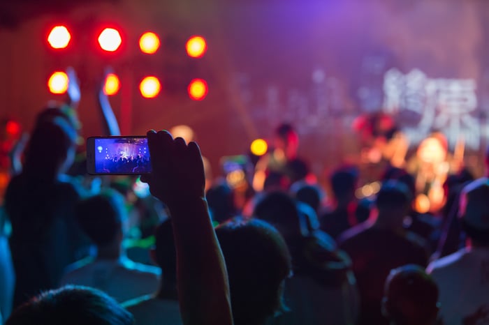 People gathered together watching a rock concert.