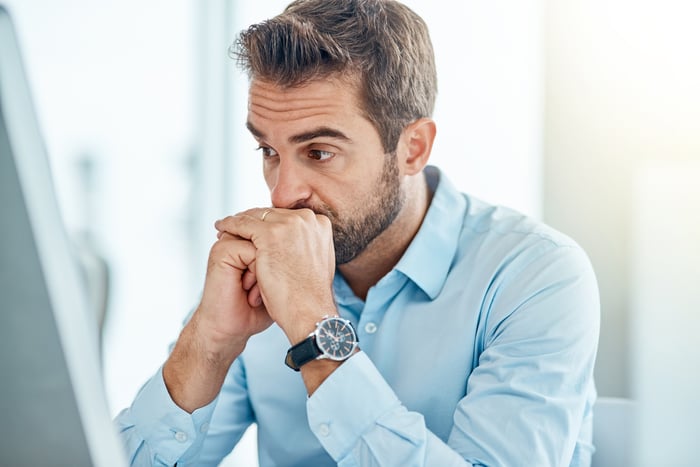 Man resting chin on hands with serious expression