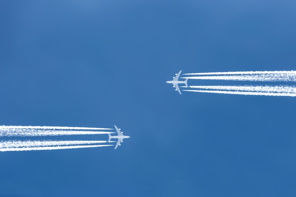 2 airplanes flying in opposite directions towards each other