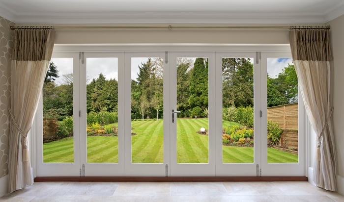 A wall with sliding doors leading to a garden.