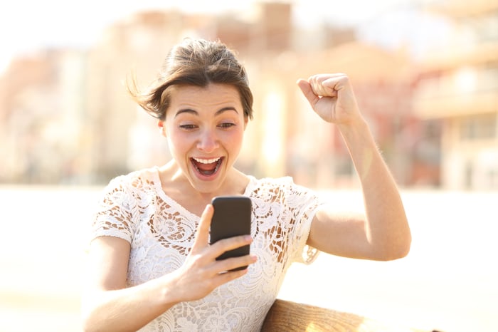 Excited woman reading  on phone. 