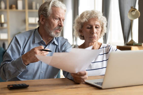 Older man and woman at laptop with concerned expressions