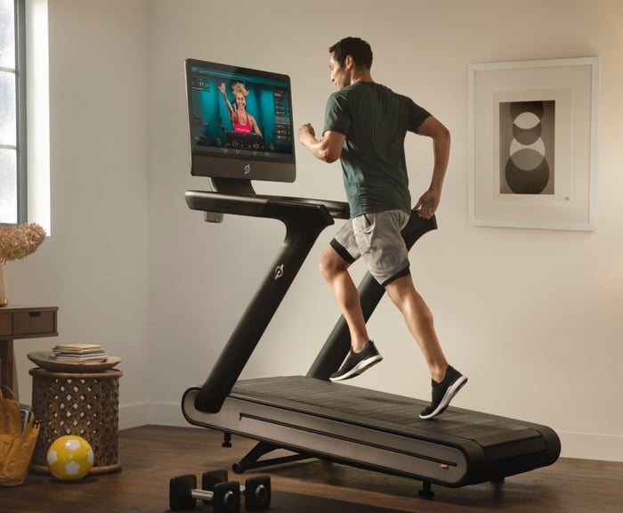 Young or middle-aged man running on a Peloton treadmill.