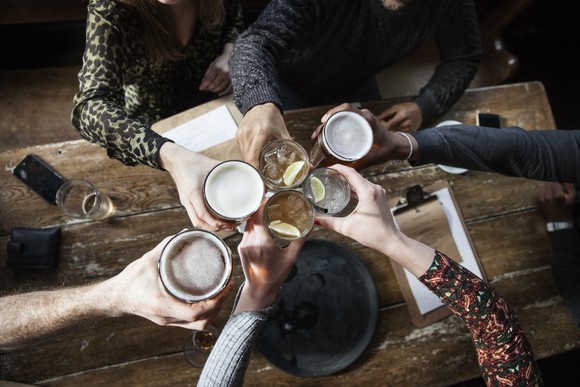 A group of people clinks glasses at a restaurant.