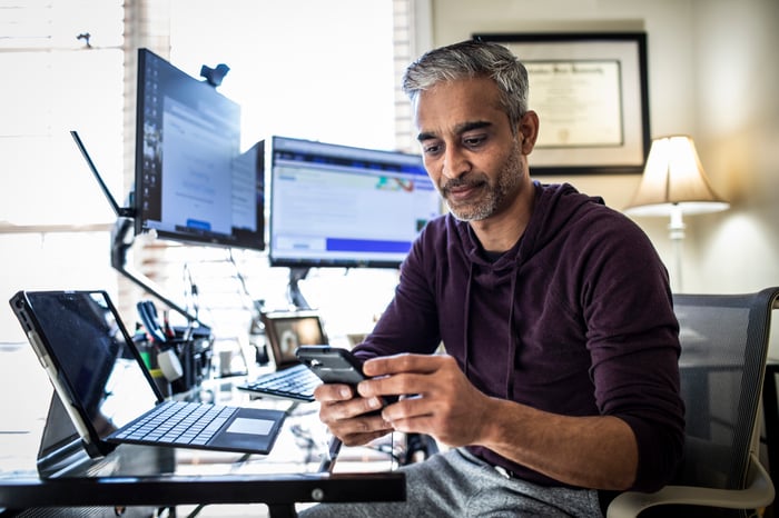 A man with several computer screens working from home.