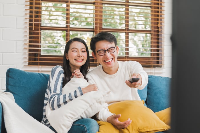 Two people watching TV on a couch.