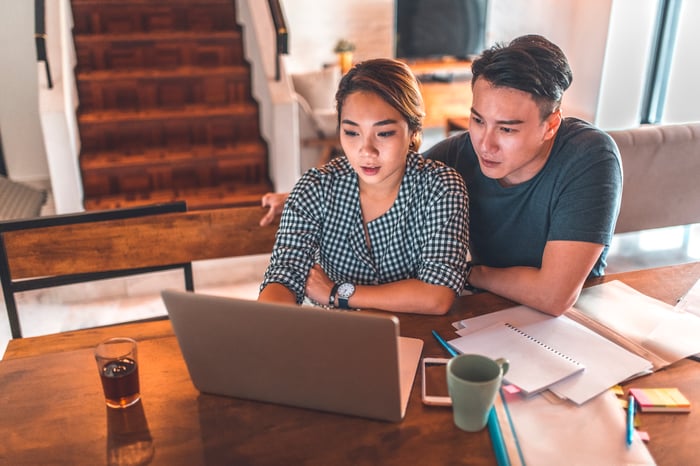 Serious couple looking at laptop and discussing finances