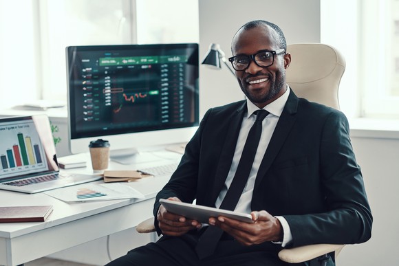 Man in suit looking at stock charts on computers