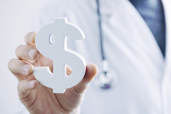 Medical pro holding dollar sign paperweight.