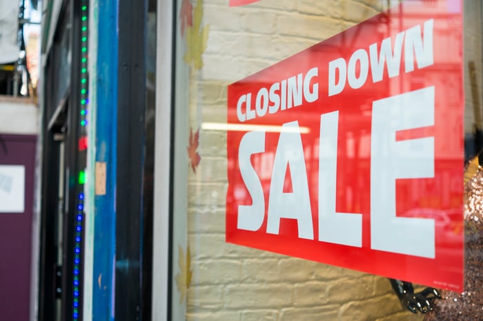 Red closing down sale sign hanging in a store window