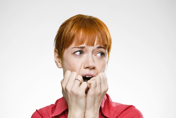 A woman biting her nails.