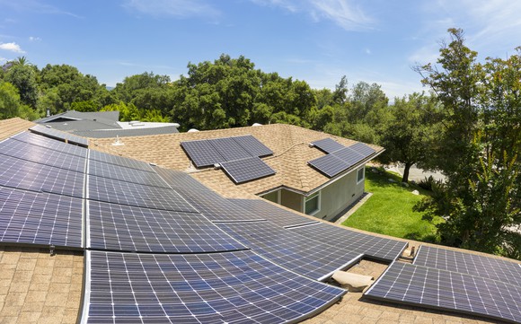 Solar panels on a residential roof on a sunny day seen from tp of roof looking down.