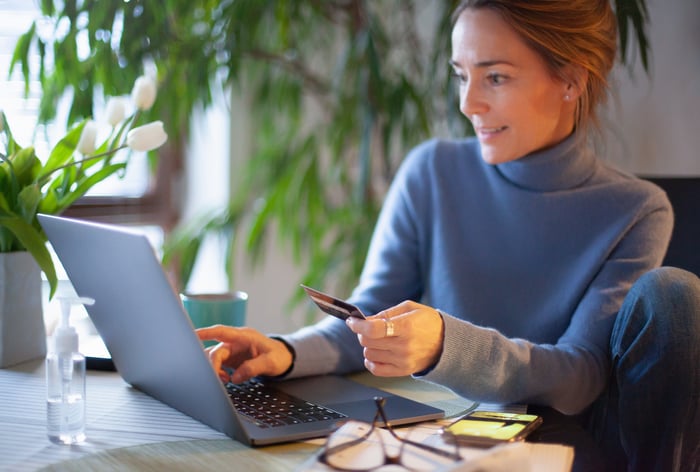 Woman using credit card while using her computer