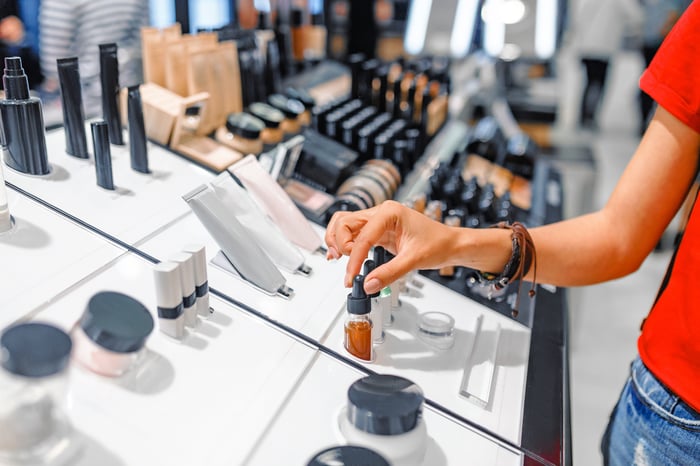 A woman standing at a makeup display.