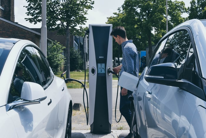 EVBox charging station with man getting ready to plug into his EV