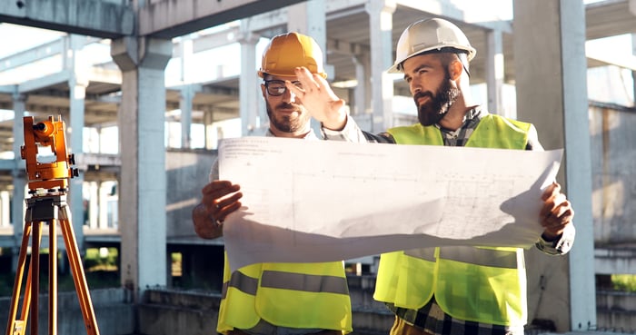 Construction workers looking at a blueprint on a jobsite.