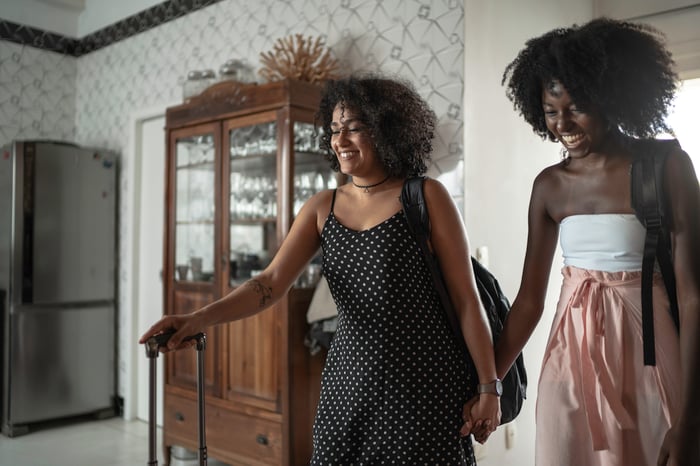 Two women with luggage arriving at a bed and breakfast. 