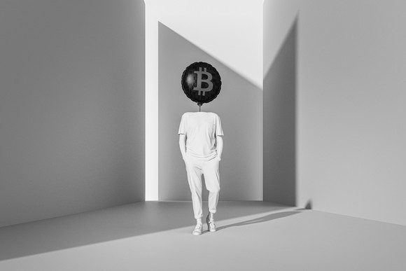 Person walking with their head replaced by a bitcoin balloon