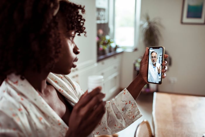 Person video-chats with a physician over a cell phone.