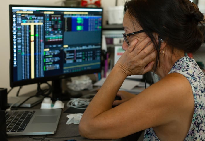 An older person looking at stock charts on their computer.