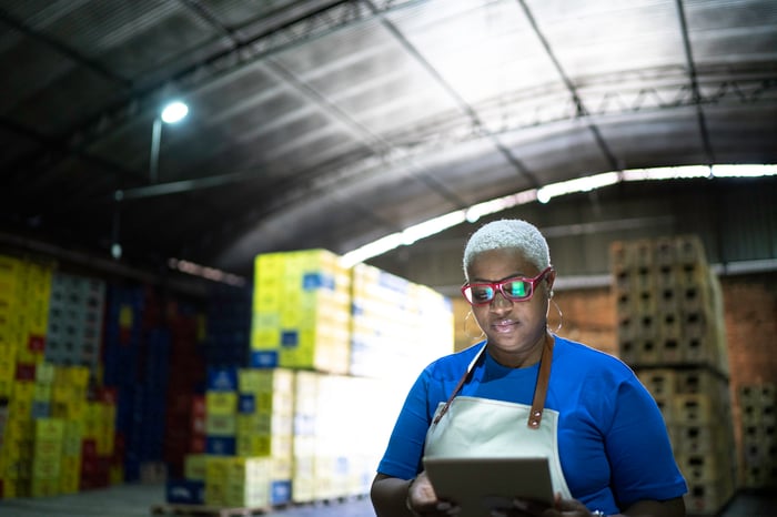 A worker uses technology in a warehouse.