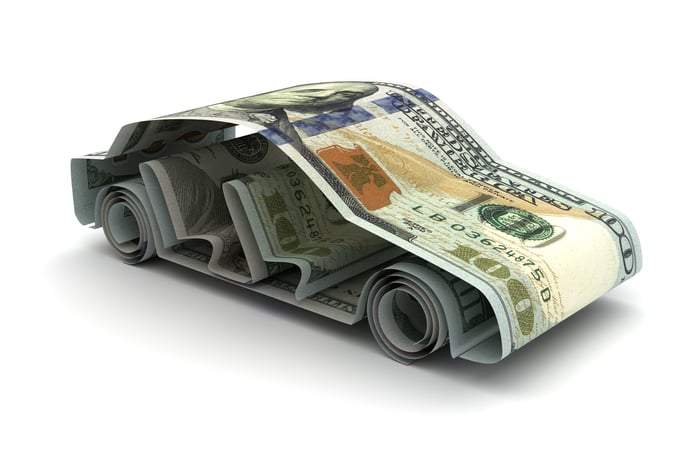 Multiple one hundred dollar bills folded into the shape of a car. 