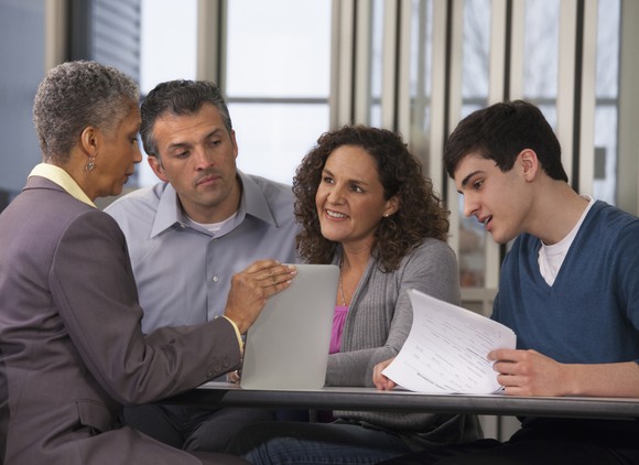 A bank worker giving a group of clients papers to look through.