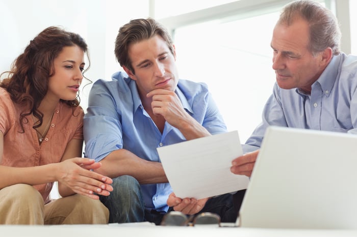 Couple looking at paper with advisor