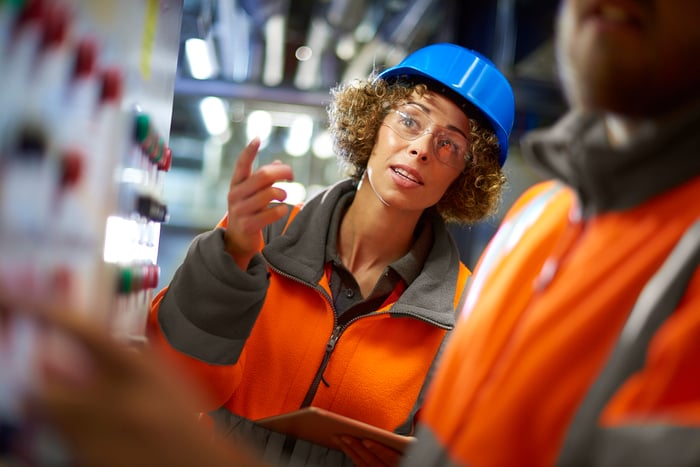 Two people working at a control panel in a boiler room at a power station.