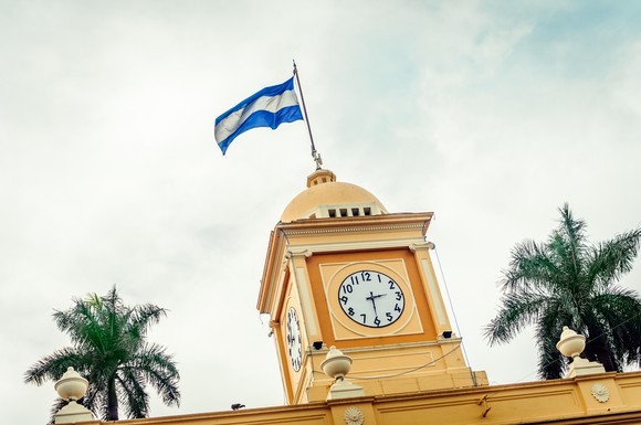 The flag of El Salvador flies above the clock tower of a building in the city of Santa Ana, El Salvador.